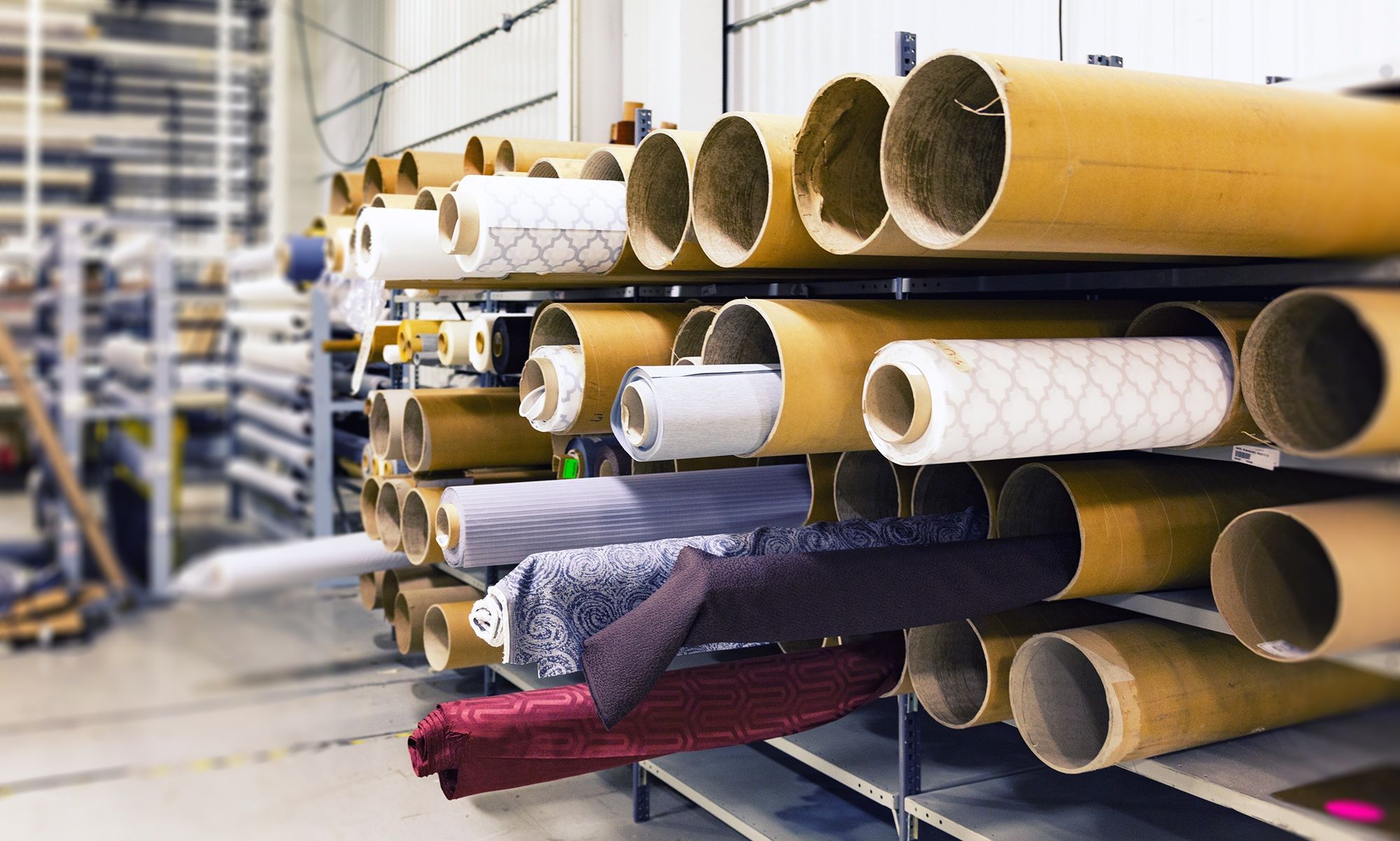 Licensed photograph of textile rolls in an industrial warehouse, representing materials kept in circulation.