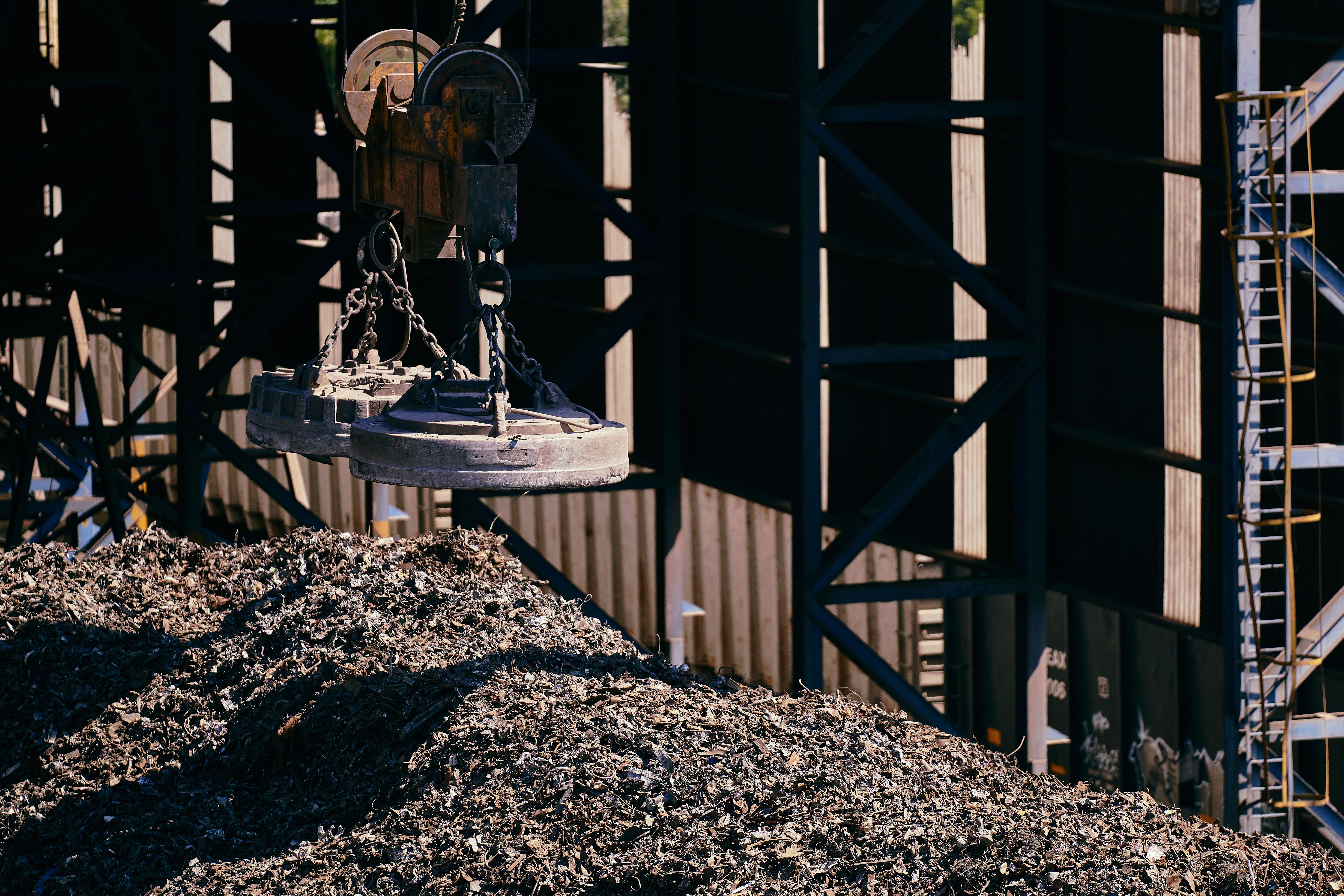Licensed photograph of industrial equipment handling scrap metal in a recycling facility.
